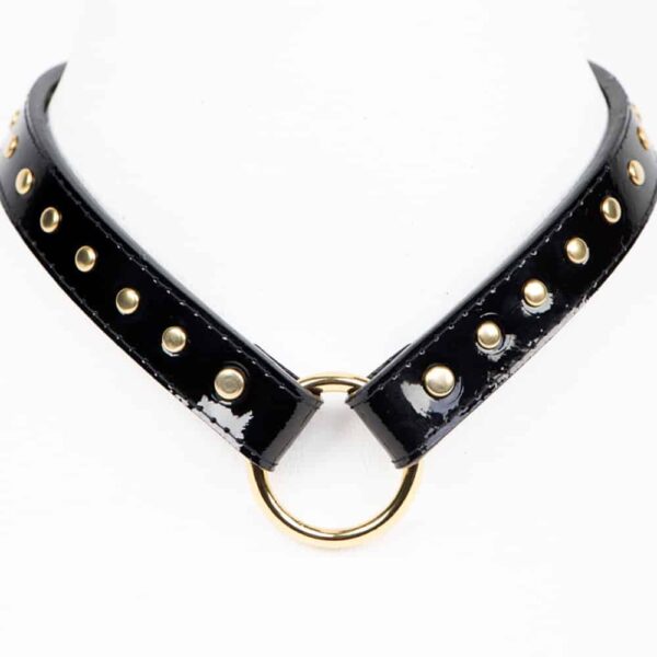 The Ricco Collar & T-Strap from Fraulein Kink. A most versatile restraint, the Ricco T-Strap! Handcrafted to order from black Italian patent leather and adorned with gold brass double cap rivets. With detachable Fräulein Kink leash in relief. These straps are strong and ultra versatile! T-strap options: handcuffs, collar, leash, restraint and even use as a leather kitten tail when attached to the back of one of our leather garter belts.