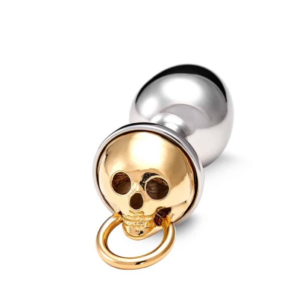 Accessory anal plug in silver bronze and skull decoration in gold.