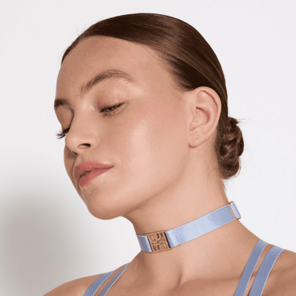 Femme qui porte un choker bleu ciel strap fin et détails avec logo doré