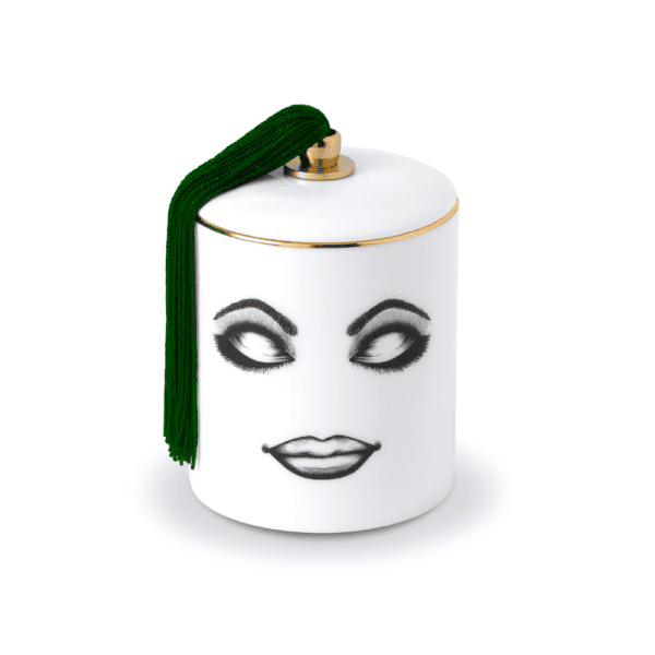 Vela perfumada de porcelana china blanca con fieltro negro que representa un rostro relajado con los ojos cerrados y ligeramente maquillado con detalles verdes y dorados.