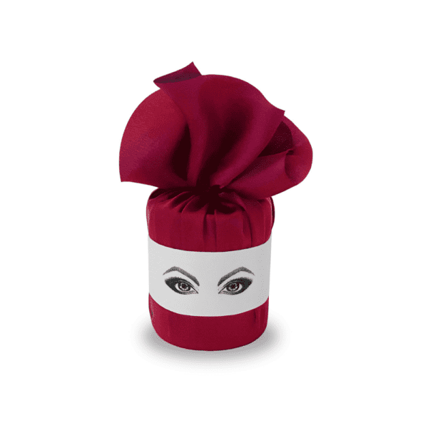 White Chinese porcelain candle wrapped in red textile with felt markings of a face with made-up eyes.