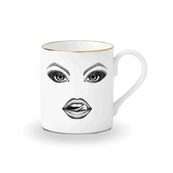 Una cautivadora taza de porcelana blanca, adornada con un mono dibujado con precisión en fieltro. El mono se burla con picardía, pasándose la lengua por los labios. La ilustración, realizada con delicadeza con un rotulador de punta fina, evoca el estilo Provocateur y se inspira en Ilona Staller.