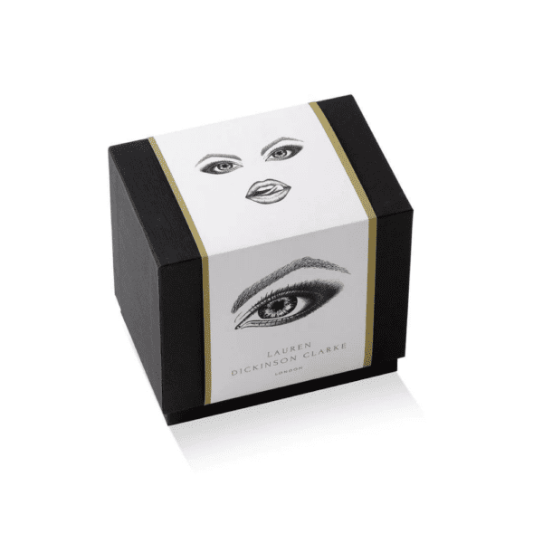 El envase, especialmente diseñado para las velas provocadoras, es de color negro y presenta ilustraciones de ojos, complementadas con un elegante acabado dorado.