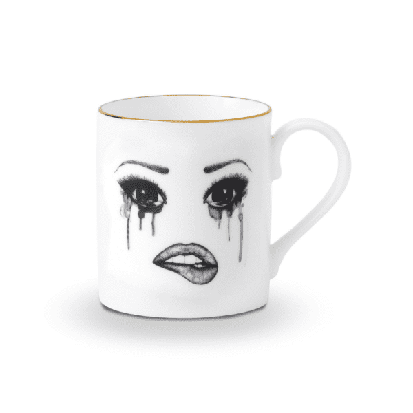 A white Chinese porcelain cup features a melancholy face, carefully traced in felt. This face expresses sadness with flowing tears and melting make-up, while the lower lip is delicately bitten, creating a moving and artistic composition.