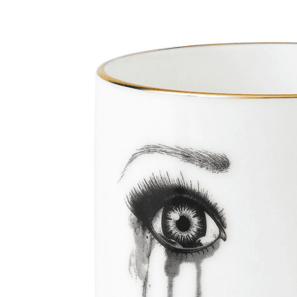 A white Chinese porcelain cup features a melancholy face, carefully traced in felt. This face expresses sadness with flowing tears and melting make-up, while the lower lip is delicately bitten, creating a moving and artistic composition.