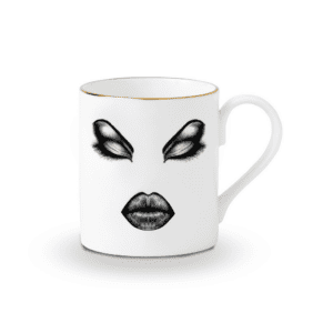 Taza de porcelana china blanca y fieltro negro preciso que representa el rostro de la prima donna maquillada, ojos cerrados, labios carnosos.