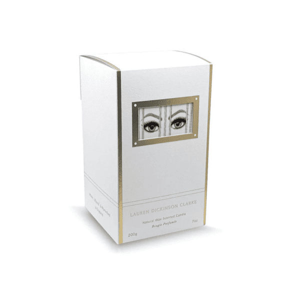 Die Verpackung der Kerze hat eine weiße Farbe mit goldenen Akzenten und ist mit einem Design verziert, das Augen darstellt, die Gefangenschaft ausdrücken.