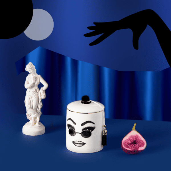 A white porcelain scented candle features a confident face, carefully traced in felt. This face expresses self-confidence, comfort and cool with round sunglasses and perfectly executed make-up.