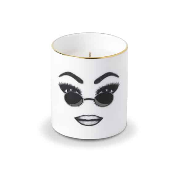 A white Chinese porcelain scented candle features a confident face, carefully traced in felt. This face expresses self-confidence, comfort and cool with round sunglasses and perfectly executed make-up.