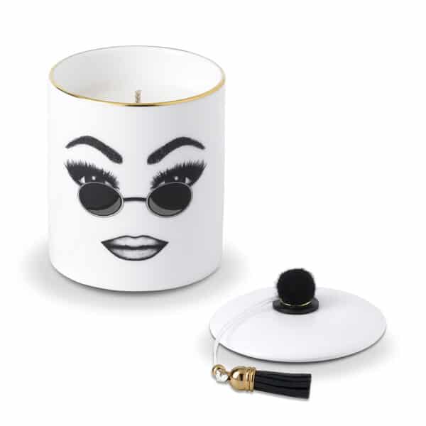 A white Chinese porcelain scented candle features a confident face, carefully traced in felt. This face expresses self-confidence, comfort and cool with round sunglasses and perfectly executed make-up.