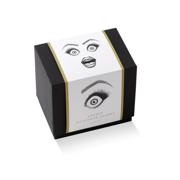 Envase diseñado para tazas, en negro con ilustraciones de ojos y un elegante acabado dorado.