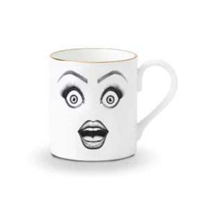 Una taza de porcelana china blanca presenta un dibujo en fieltro negro de una cara sorprendida con ojos muy asombrados y boca abierta, todo ello realzado con detalles dorados.