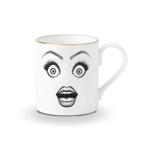 A white Chinese porcelain cup features a black felt drawing of a surprised face with very shocked eyes and an open mouth, all enhanced with gold details.
