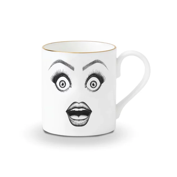 Une tasse en porcelaine chinoise blanche présente un dessin en feutrine noire illustrant un visage surpris avec des yeux très choqués et une bouche ouverte, le tout rehaussé de détails dorés.