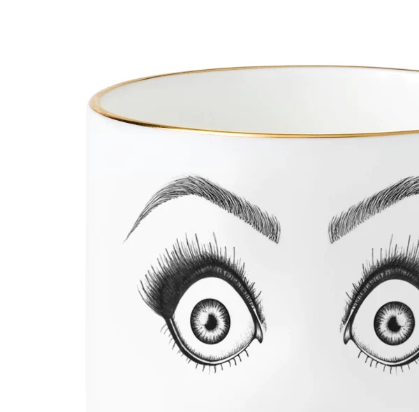 Detail einer Tasse aus weißem chinesischem Porzellan mit einer schwarzen Filzzeichnung, die ein überraschtes Gesicht mit sehr schockierten Augen und einem offenen Mund zeigt, das durch goldene Details hervorgehoben wird.