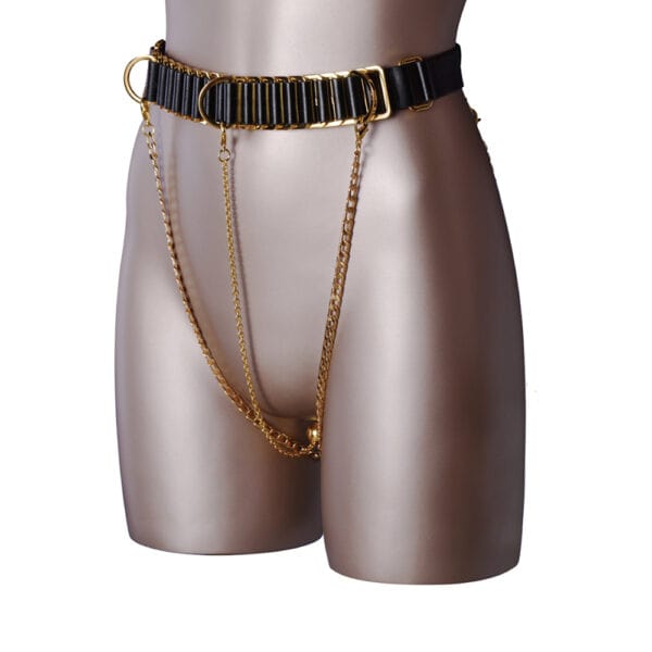 Fotografía tomada a un maniquí en la que se ve un cinturón negro con detalles dorados del que cuelgan dos cadenas.