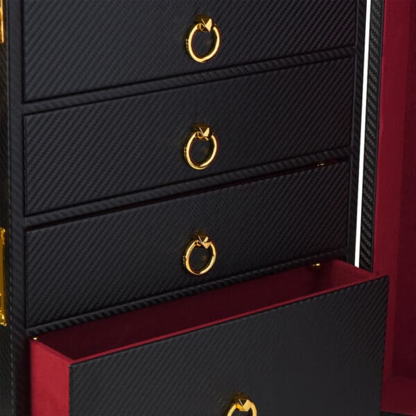 Fotografie des Inneren eines Koffers, die die schwarzen Lederschubladen mit einem roten Samtboden zeigt. Die Griffe sind in Form von goldenen Kreisen .