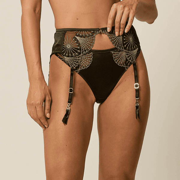 Zoom in on the garter belt worn by a woman from the front. Monarchy suspender belt by Vixen & Fox.
