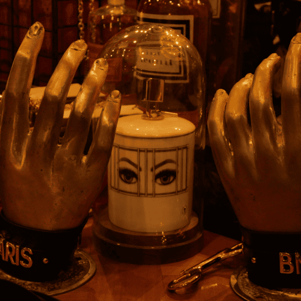 Photograph of hands in our with leather handcuffs and a prison mug under a warm light