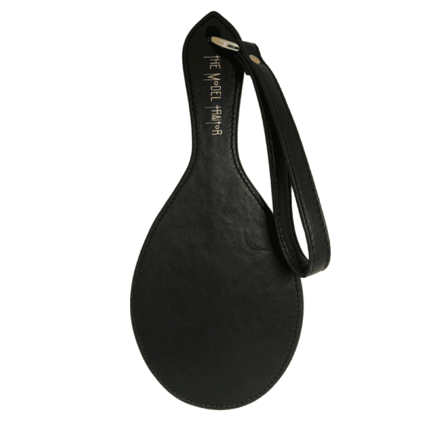 Photograph on white background of the Paddle Fessée Leather in black with gold details