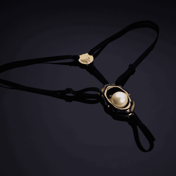 Bijou clitoridien “Moist Eyes” de UPKO avec stimulateur ergonomique et perle roulante. G-String ajustable, détails dorés, alliage de zinc hypoallergénique pour une stimulation et un confort optimaux.