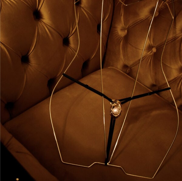 UPKO G-String Bijou Clitoridien en un maniquí en la sala de exposición, en un sillón.