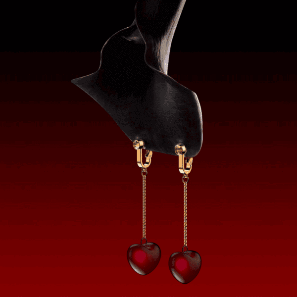 Fotografía de una flor negra invertida de la que cuelgan joyas en forma de campana de clítoris con cerezas en forma de corazón.