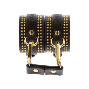 Foto von schwarzen Handschellen aus Leder mit goldenen Details.