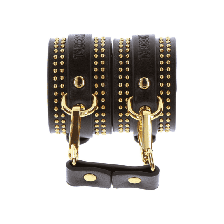 Schwarze Handschellen aus Leder mit goldenen Details.