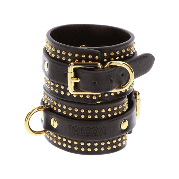 Black leather handcuffs with gold details.