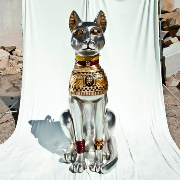 Statue einer Katze, die Hals- und Armbänder von Una Burke trägt.