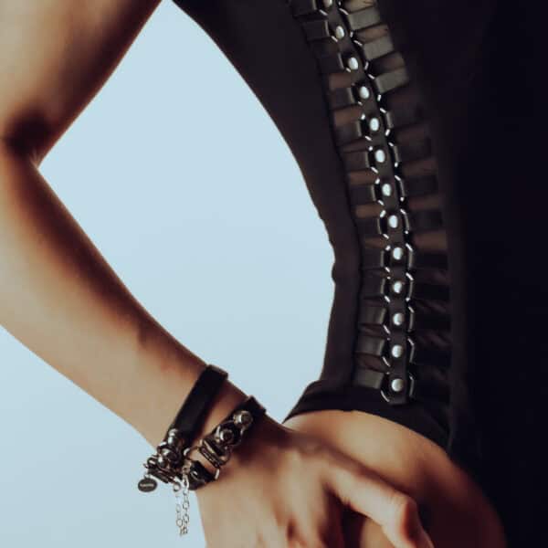 Lalita's Accented bodysuit in soft bamboo hugs curves with handmade metal embellishments, and the HerCuff bracelet in Italian leather and sterling silver with hanging hearts creates a sensual, bold contrast.