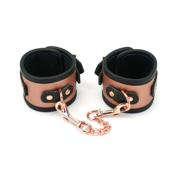 Puños de piel de vacuno color oro rosa con detalle de cadena metálica color oro rosa y forro de piel sintética ultrasuave