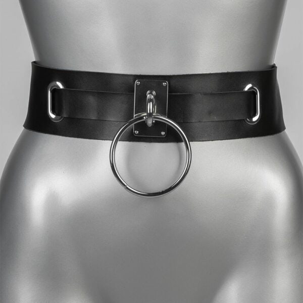 Wide black leather belt with a large silver ring at the front, sold by Brigade Mondaine, creating a bold, modern look.