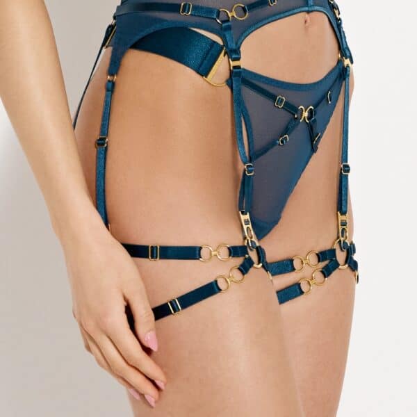 NARA Bordelle AW26 Bondage Strumpfbänder aus elastischem Satin Signature, vollständig verstellbar. Ketten und Ring sind mit 24 Karat vergoldet. Anpassbare Einheitsgröße (35-60 cm). Farbe Teal Blue. Made in Europe.