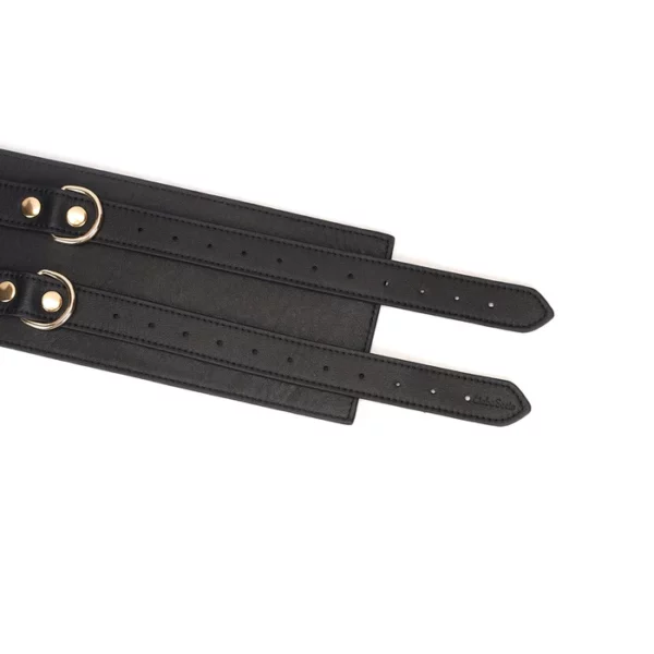 Cinturón bondage de cuero negro de la colección Dark Secret. Fabricado a mano con acabado dorado y dos anillas en D para su sujeción. Un accesorio lujoso y refinado para la dominación.