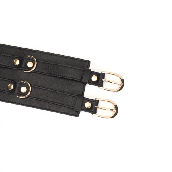 Cinturón bondage de cuero negro de la colección Dark Secret. Fabricado a mano con acabado dorado y dos anillas en D para su sujeción. Un accesorio lujoso y refinado para la dominación.