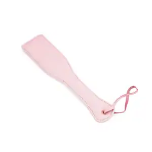 Paleta de cuero rosa de la colección Fairy, fabricada en piel de cordero blanca y rosa con detalles en oro rosa. Un accesorio BDSM refinado para juegos de azotes controlados y elegantes.