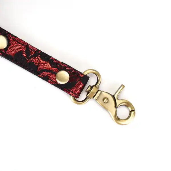Cross-over hogtie in ruby red imitation leather adorned with black lace and gold metal details