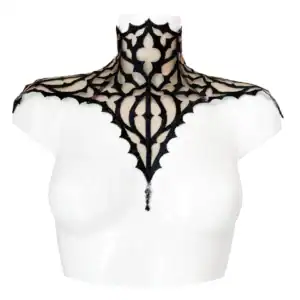 Plastron gothique brodé noir sur tulle nude, orné d’un pendentif central. Forme montante couvrant cou et épaules. Fermeture réglable par ruban façon corset au dos.