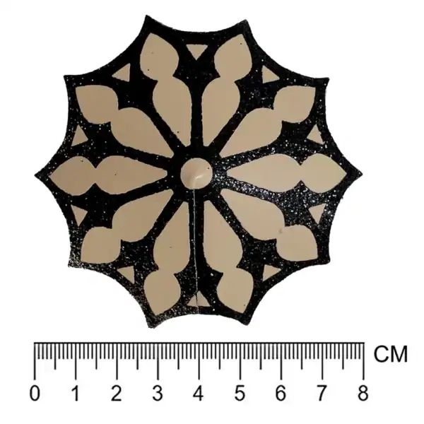 Selbstklebende Nippelabdeckungen mit schwarzem, glitzerndem Gothic-Rosettenmuster auf nudefarbener Basis. Weiches Material, flexibel und wiederverwendbar. Elegantes Lingerie-Accessoire aus der DOGMA-Kollektion.
