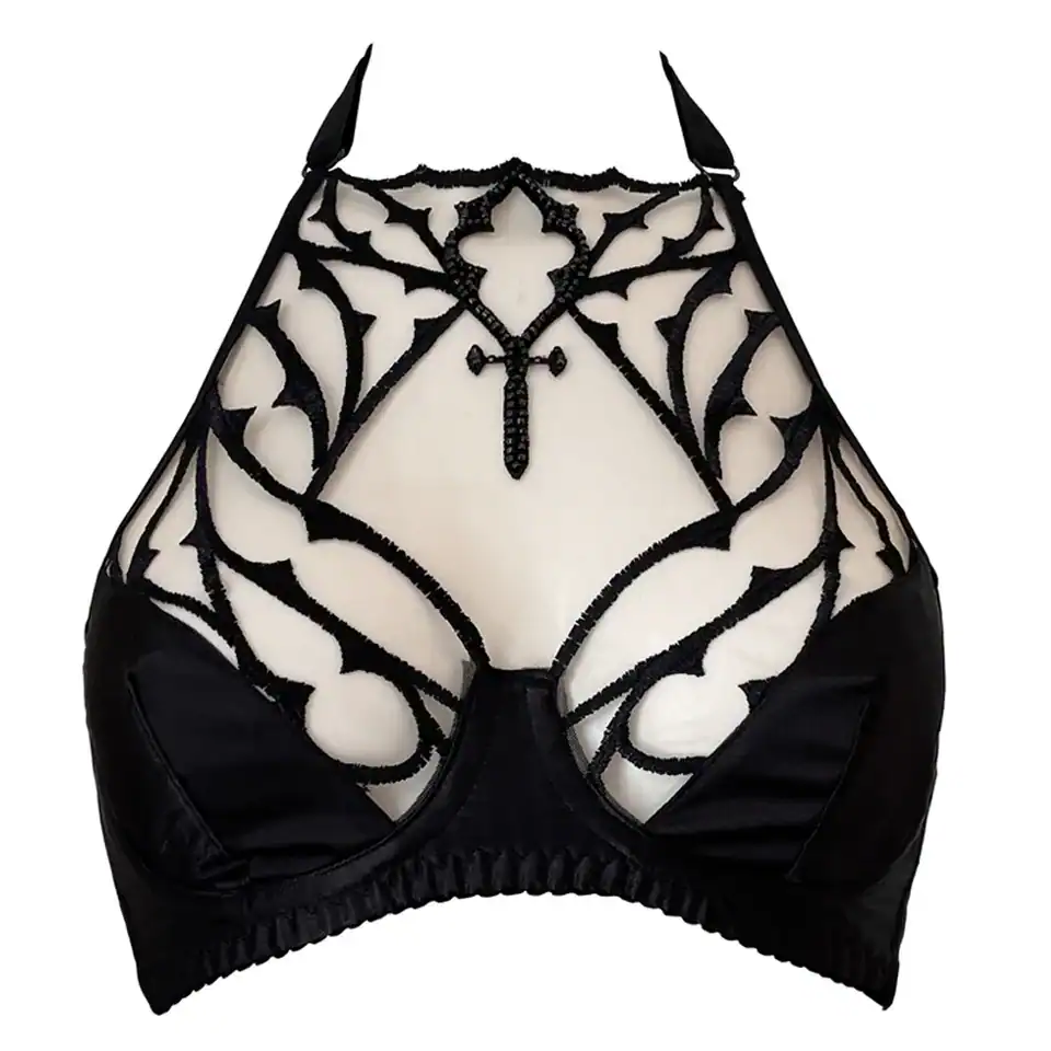 Soutien-gorge gothique en tulle nude brodé noir avec perles facettées. Demi-bonnets en satin noir doublé et col licou réglable. Élégance dramatique et maintien confortable.