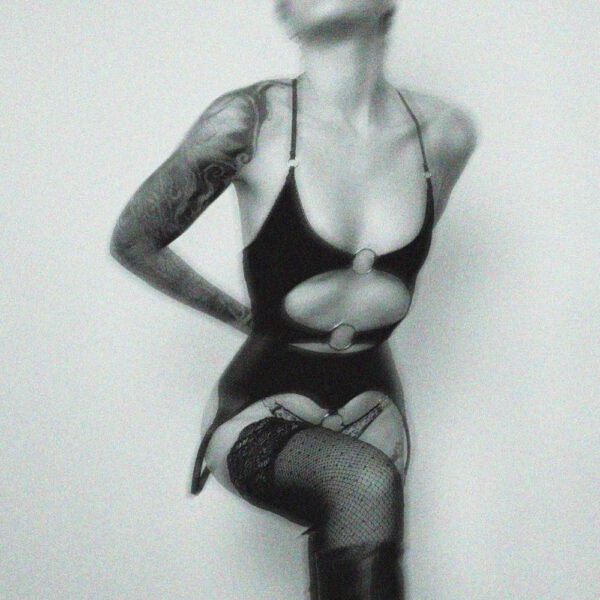 Lingerie en jersey extensible alliant douceur et provocation. Coupe ouverte avec anneaux métalliques argentés, élastique picot, noué au dos et bretelles réglables pour un ajustement personnalisé.