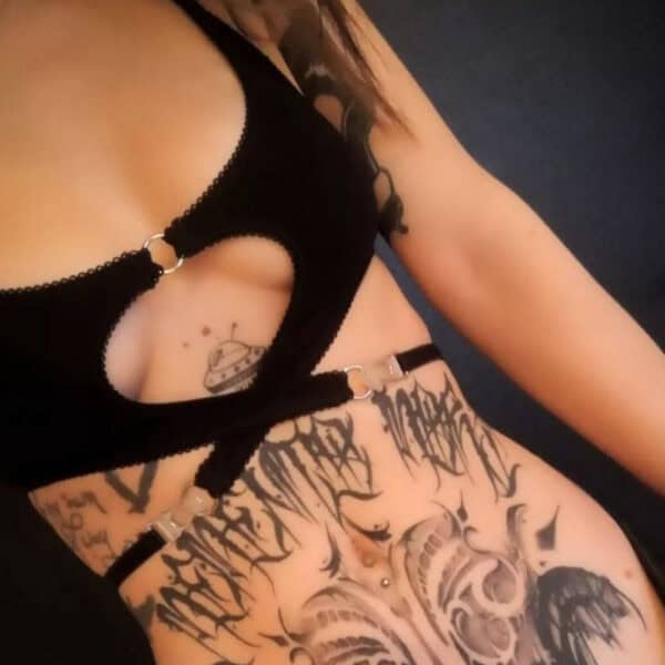 Lingerie réversible en tissu extensible doux, avec découpe cœur graphique et anneau métallique argenté central. Élastique picot et bretelles ajustables pour un confort optimal.