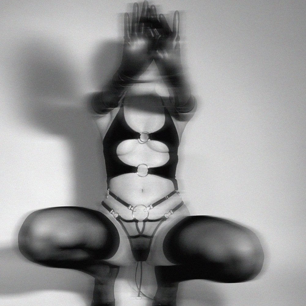 Dessous aus dehnbarem Jersey, die Weichheit und Provokation vereinen. Offener Schnitt mit silbernen Metallringen, Picot-Gummiband, im Rücken gebunden und verstellbaren Trägern für eine individuelle Passform.