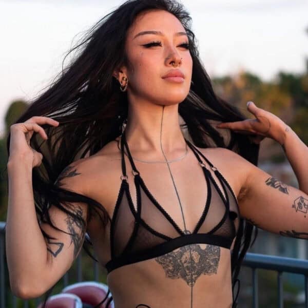 Lingerie en tulle noir à double couche, noué derrière la nuque par un élastique spaghetti. Anneaux métalliques argentés pour une touche espiègle et élégante.