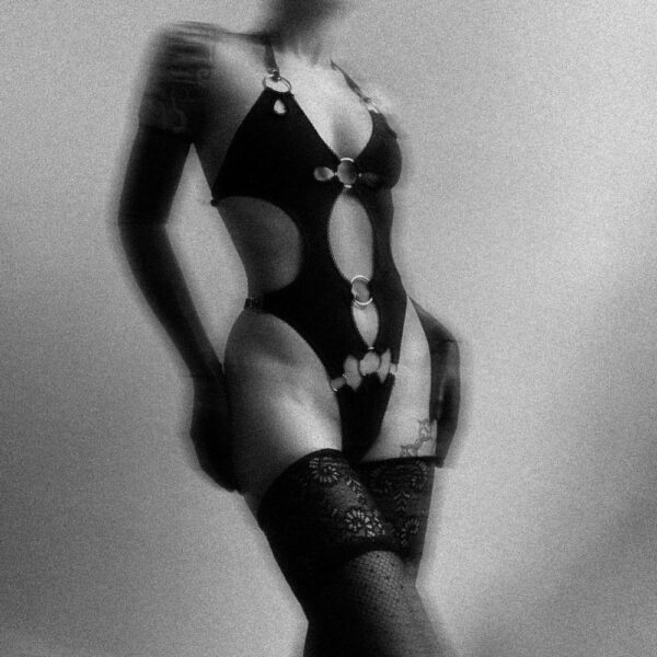 Erotische Dessous aus weichem Jersey und schwarzem Samt, gewagtes Design mit grafischen Ausschnitten und Metallringen. Verstellbare Träger für einen bequemen und sinnlichen Halt.